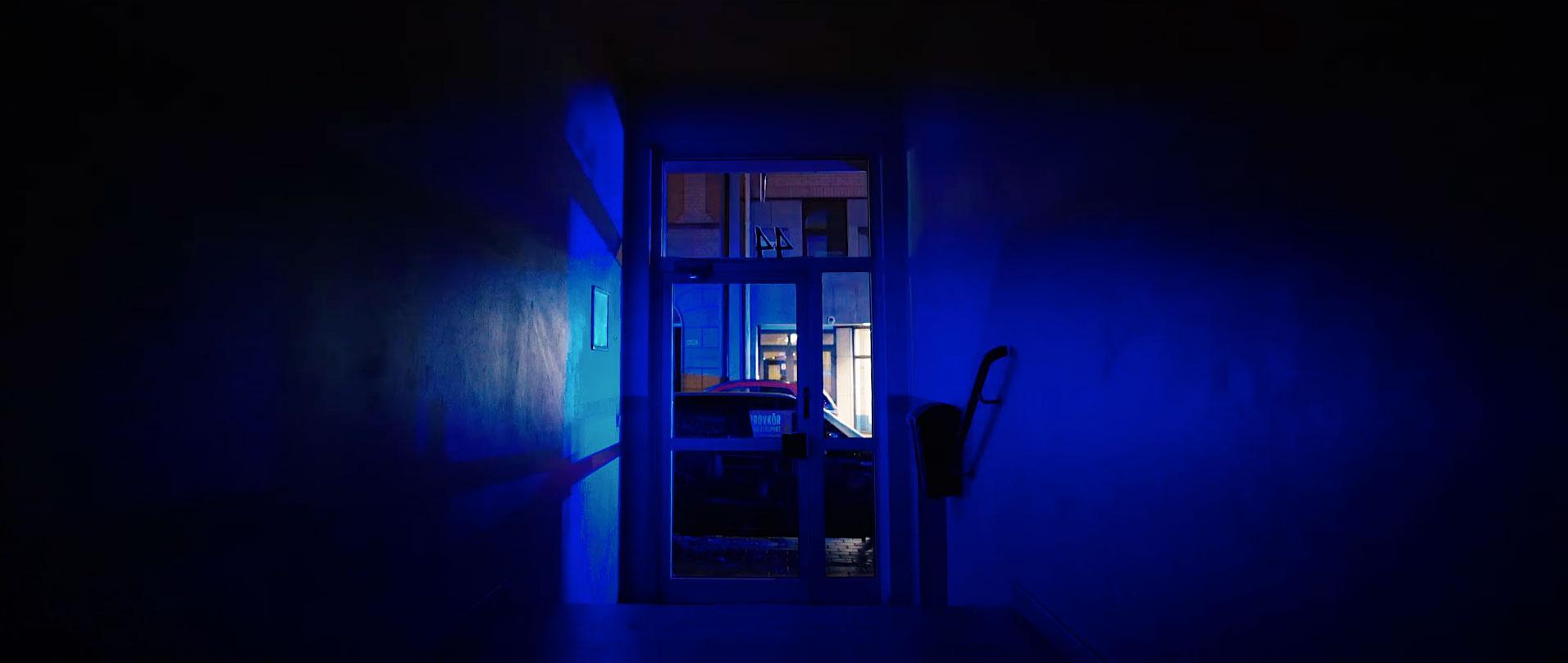 Hero Image Commercial Hallway at night lit up blue by light coming from the street through the glass door