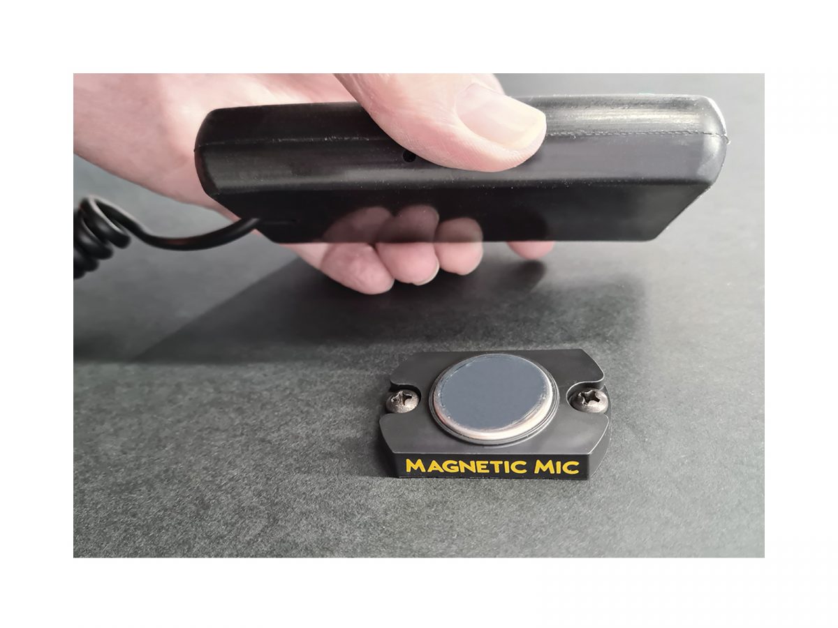 Mag Mic Mounted on Surface Action Shot Hand Approaching with Handset
