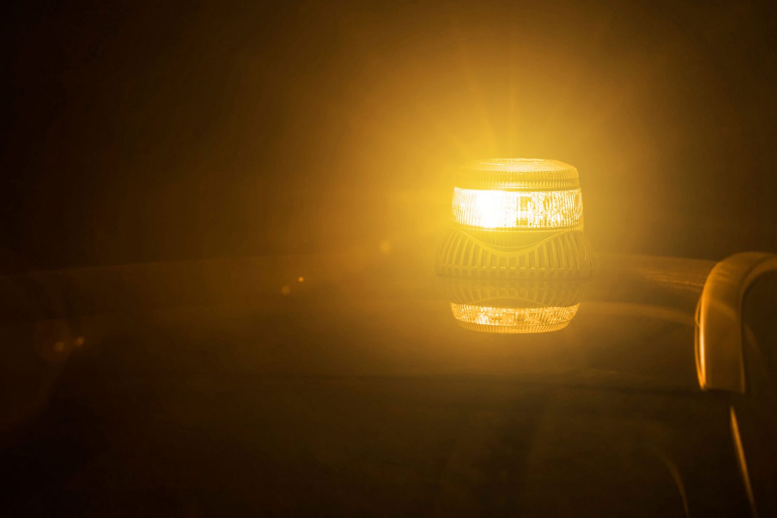 Page Image of Amber Beacon Lit on Vehicle Roof with Dark Surroundings and Reflection