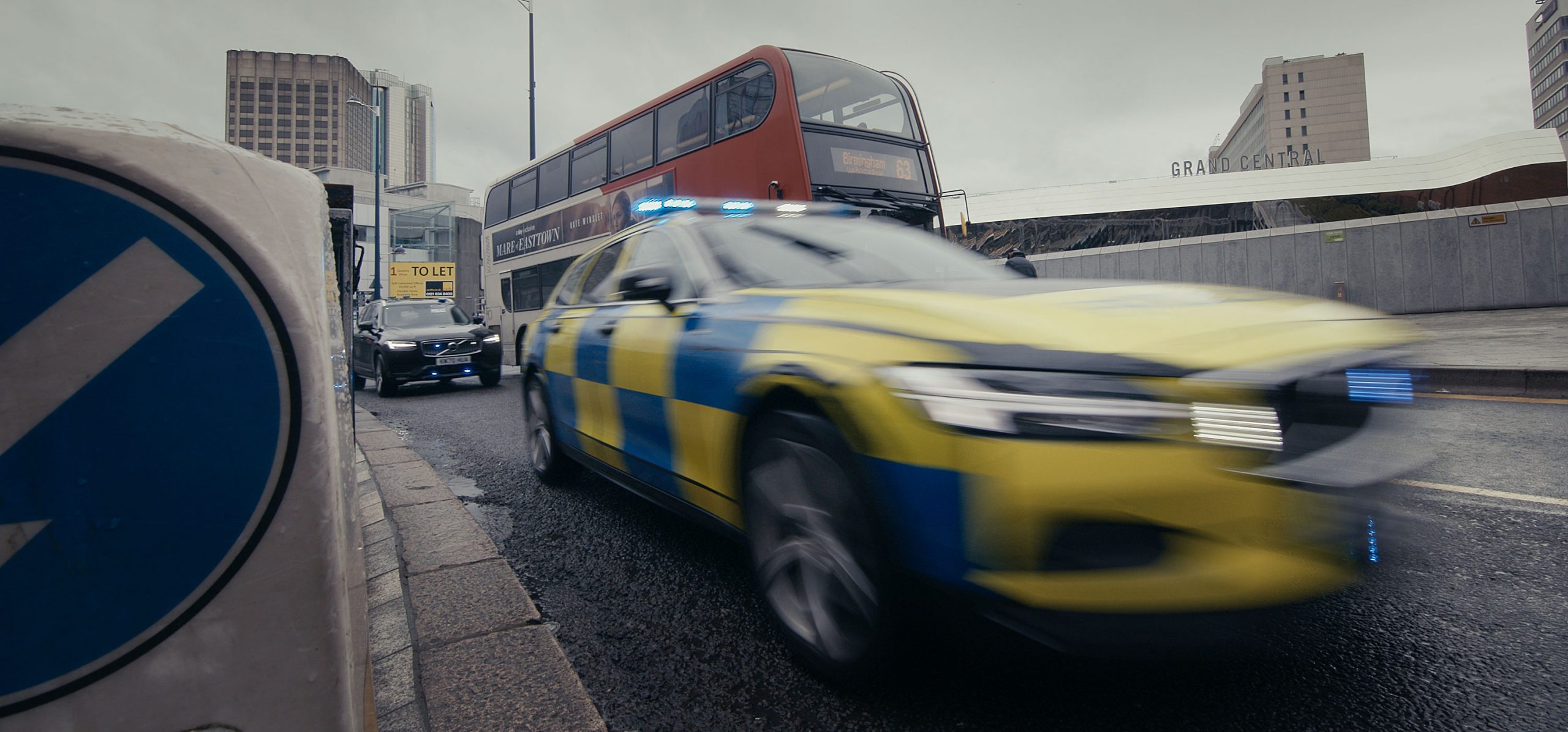 Hero Image Police Car on Road Is Driving Past with Motion Blur, Bus and Car in Background