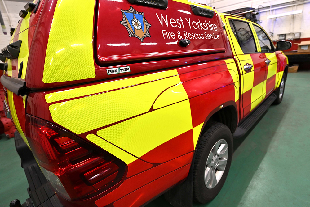 Fire response vehicle in garage at angled reverse view showing West Yorkshire Fire and Rescue Service Livery