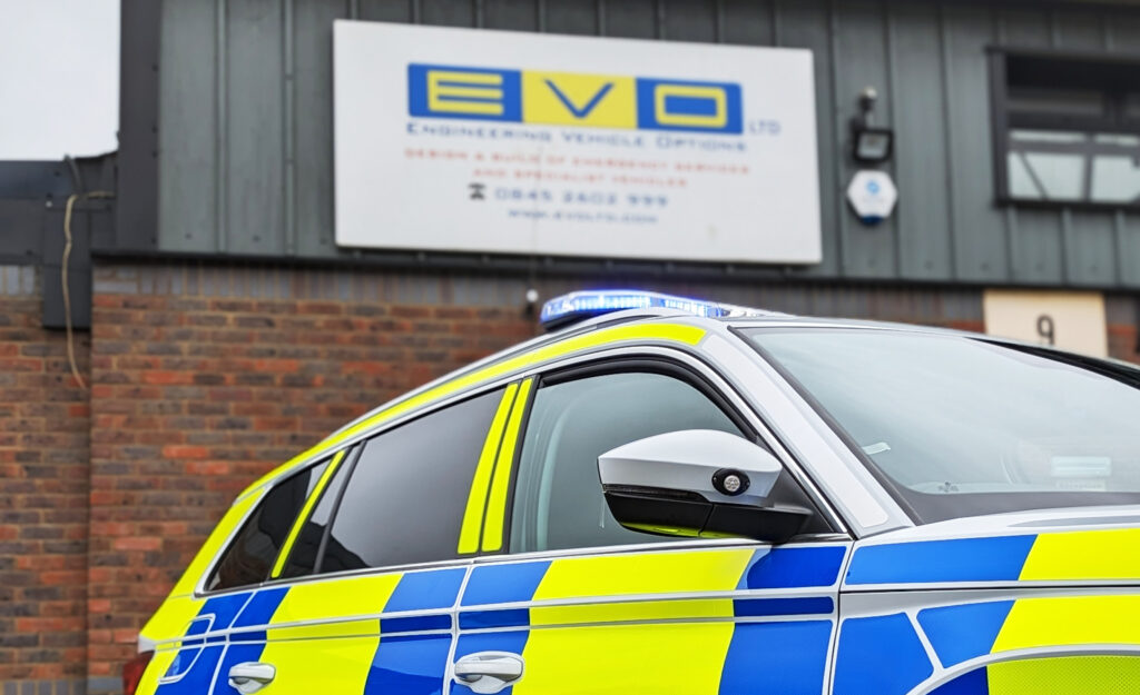 Close Up Cropped Angle Shot of Upper part of Police Skoda Kodiaq in front of out of focus building with EVO Ltd. Sign