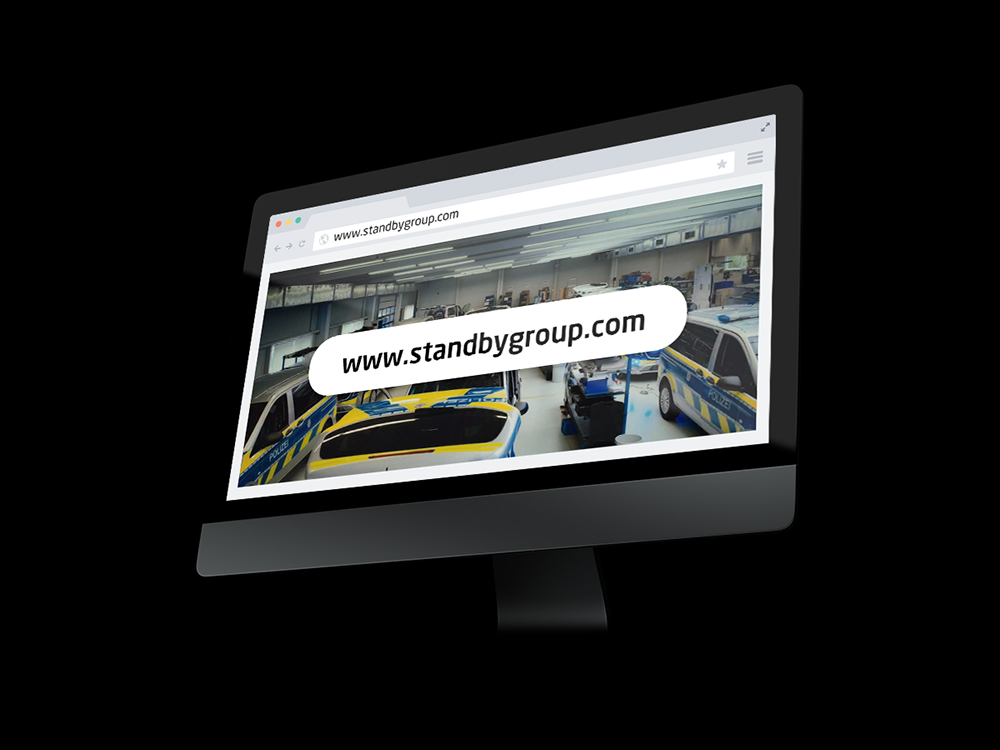 PC screen mockup at an angle on a black background showing a webpage with a big banner reading 'www.standbygroup.com'.