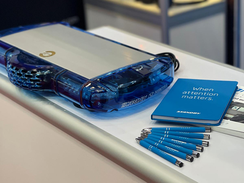 Close up of an unlit lightbar with Standby Group notepad, pens and catalogue on display at a trade show.