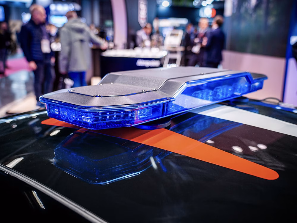 Angled view of the blue EMY Lightbar (unlit) shown on top of a black Police Nationale McLaren on the Standby France / Standby Group stand at Milipol Paris 2025.