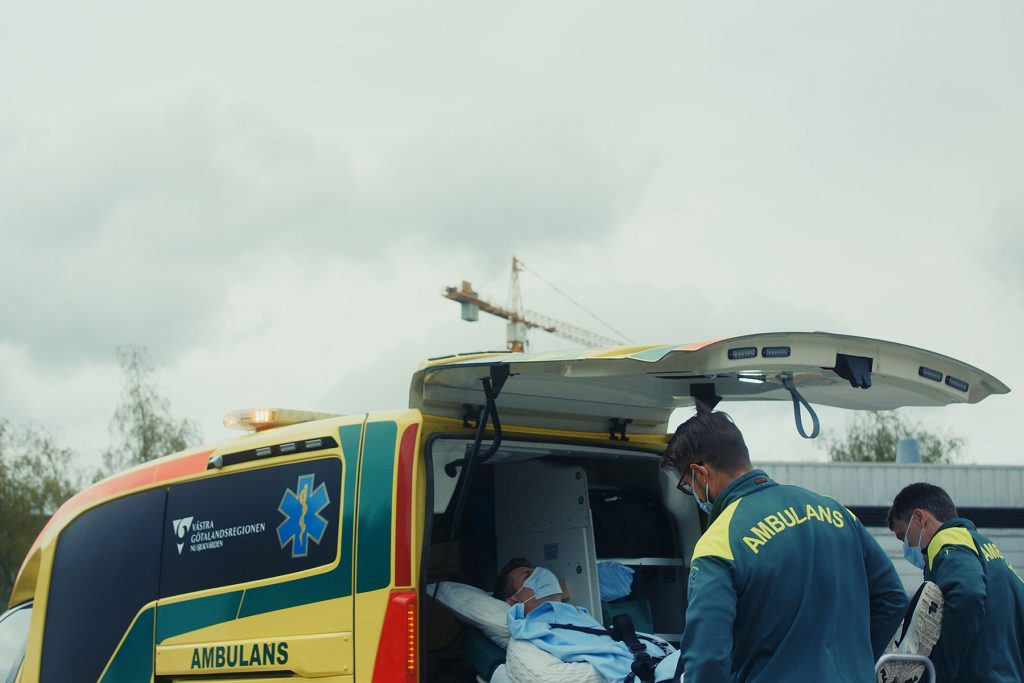Ambulanspersonal lastar in patient i ambulans.