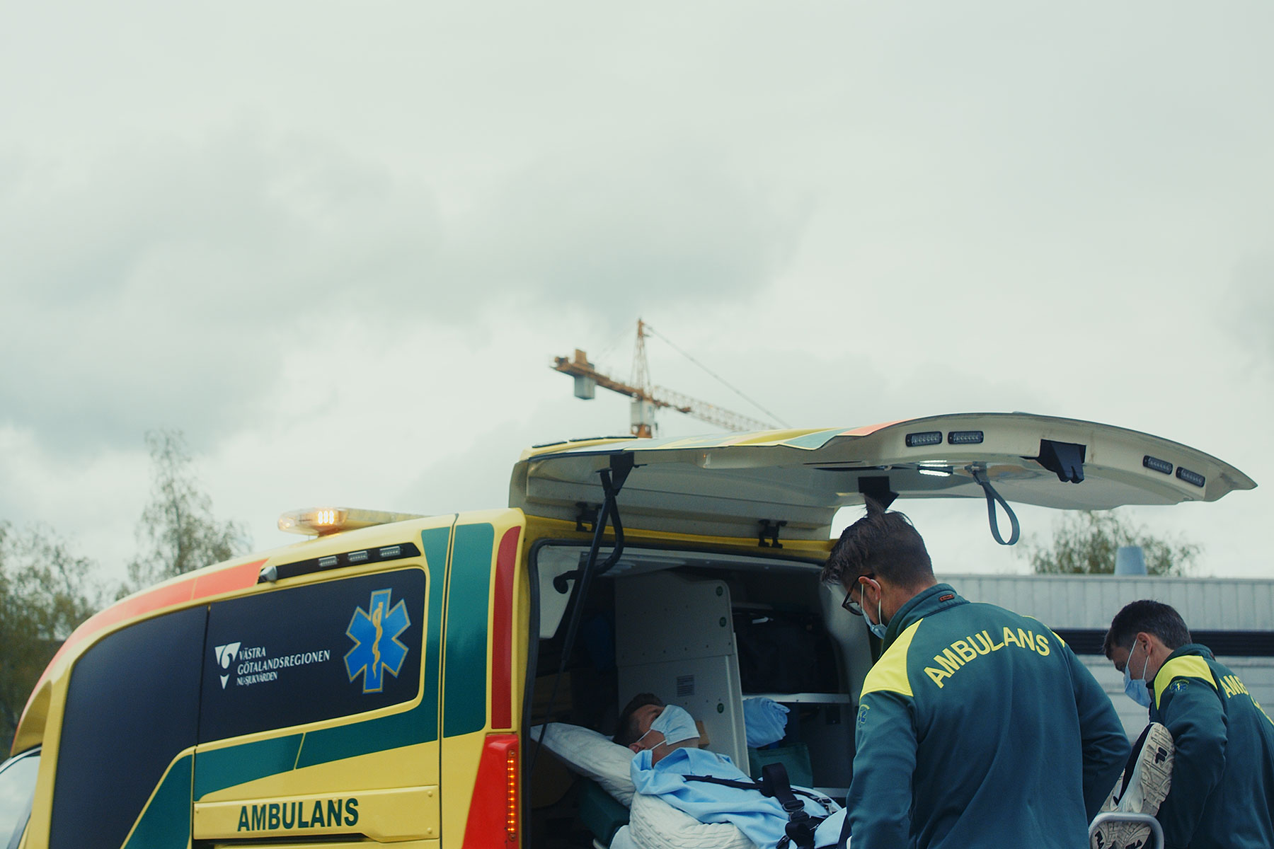 Ambulanspersonal lastar in patient i ambulans.