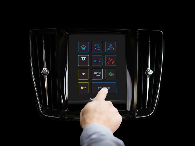 CARAT System Shown on Volvo Infotainment System on Black Background with hand Selecting 999 Arrival Button