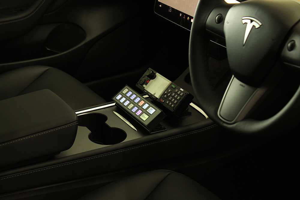 Closely cropped image of a Tesla centre console with Standby RSG Handset under emergency radio