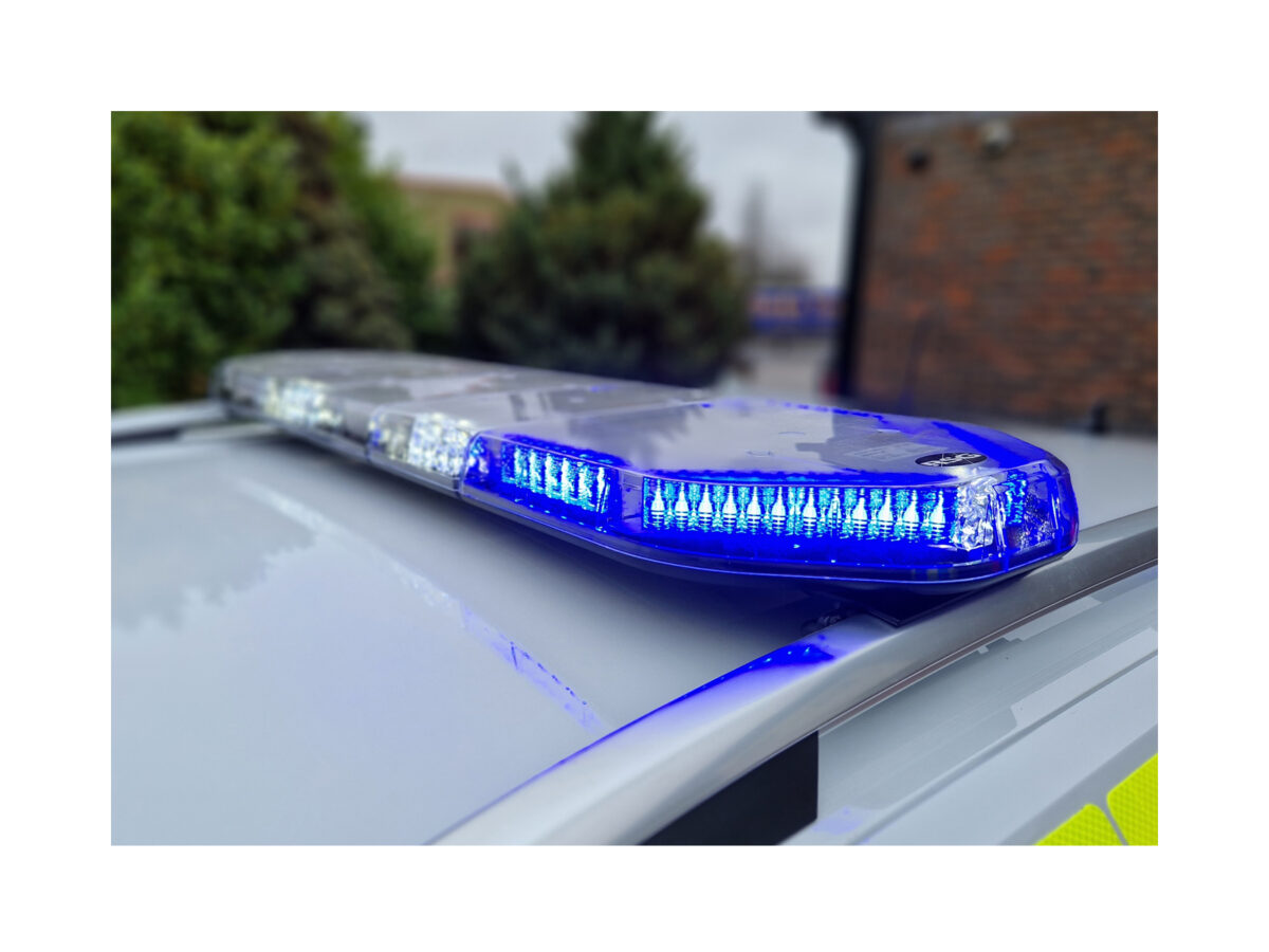 Legion LED Lightbar In Situ Lit Blue White on Police Car Roof Front in Focus, Background Blurred