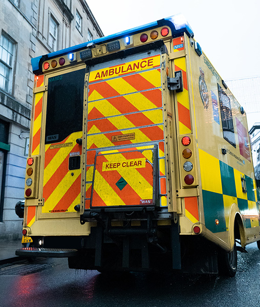 Ambulance parked on side of road, photographed from rear, road level