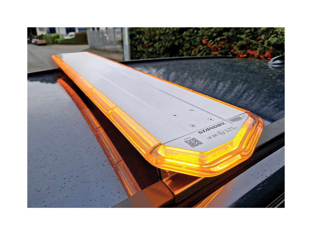 LB200 Amber angle view close up in situ on dark car roof in front of hedge and metal gates.