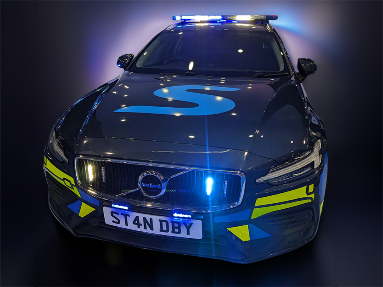 Dark colour response car with Standby UK graphics and emergency lighting on a dark background.