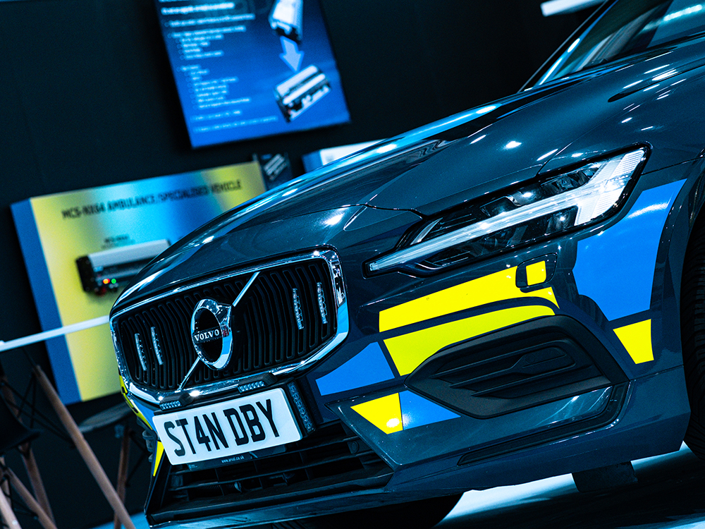 Angle view of the front end of a dark blue Volvo with Emergency vehicle livery and a Standby registration plate