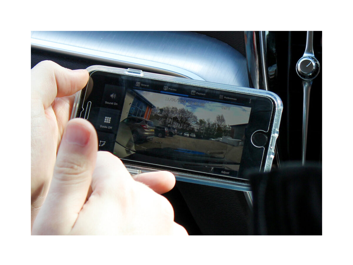 Closely cropped image of the Veyes Dash Cam App on an android phone, being held by someone in the passenger seat of a vehicle. The car dash can be seen in the background.