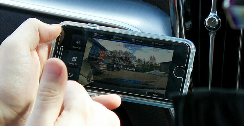 Closely cropped image of the Veyes Dash Cam App on an android phone, being held by someone in the passenger seat of a vehicle. The car dash can be seen in the background.