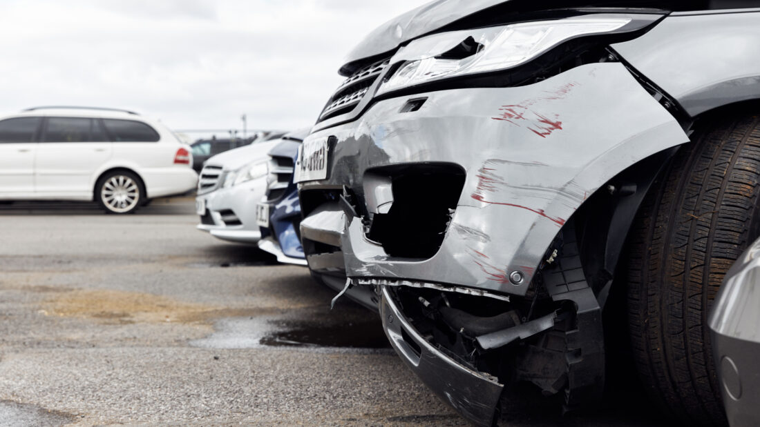 Close up of damaged bumpers side on to a row of vehicles