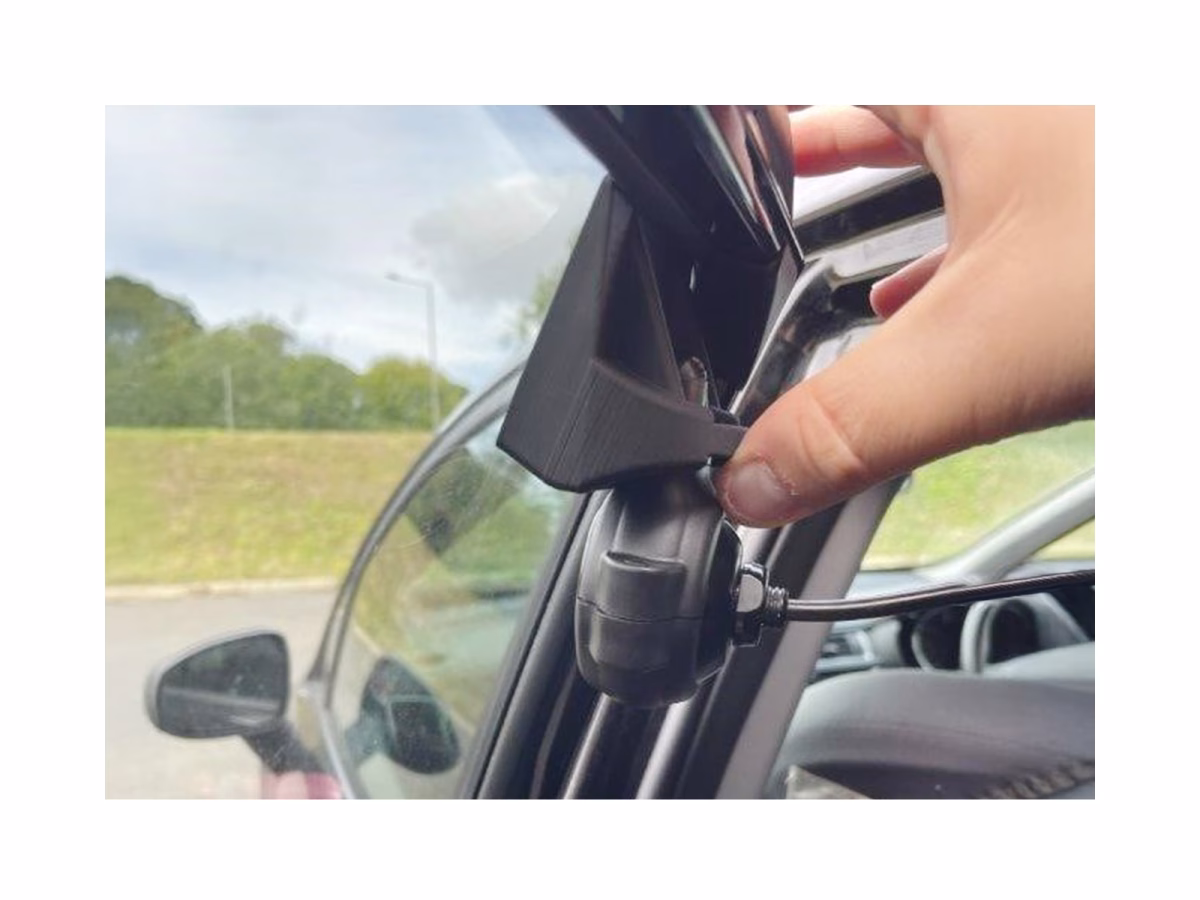 Occulux® Adjustable Glass Camera Mount Kit complete with Oculux® Wide, 1080p, AHD CCTV Camera being held up by a hand in situ on a car side window.