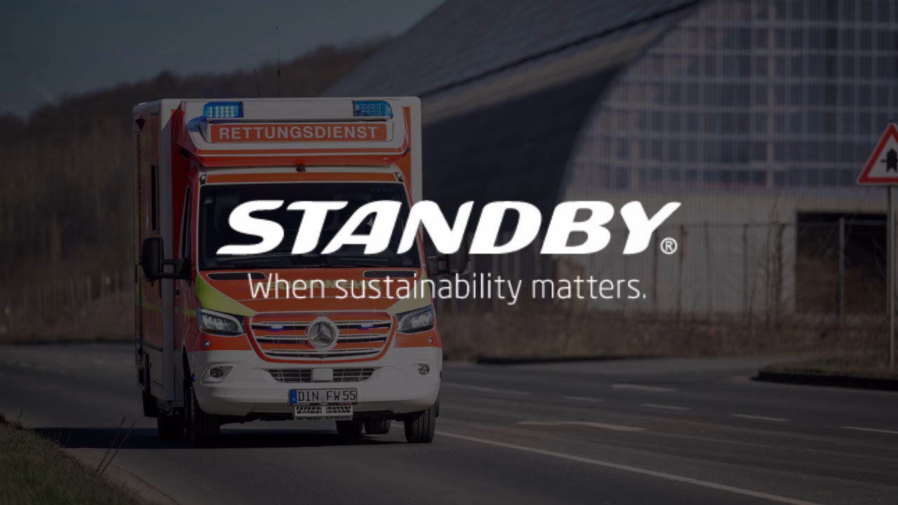 European ambulance driving down a road with dark overlay and Standby 'When sustainability matters' logo in white