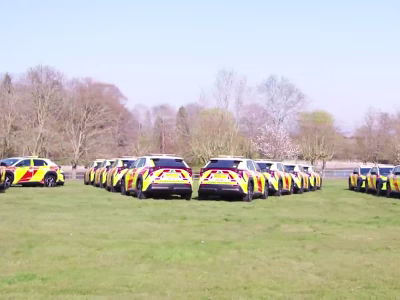 Fleet of Toyota BZ4Xs National Highways vehicles parked in lines of opposing angles in a field.