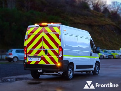 Rear angle view of a white Peugeot Boxer van with reflective chevrons across the back doors and an amber Raiden lightbar top rear, parked in a carpark at dusk.