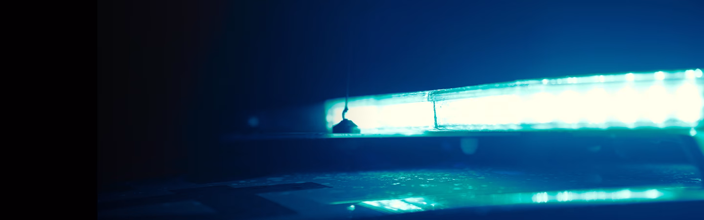 Close up angle shot of a blue Raiden LED Lightbar, reflected on the roof of a Police vehicle at night