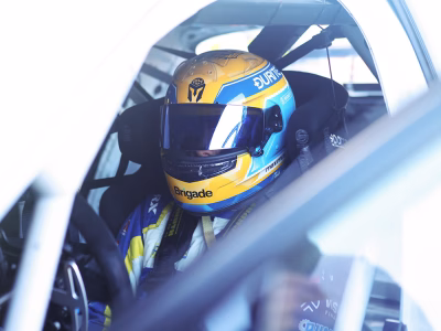 Close up shot of race driver Max Hall in racing helmet seen through an open car door