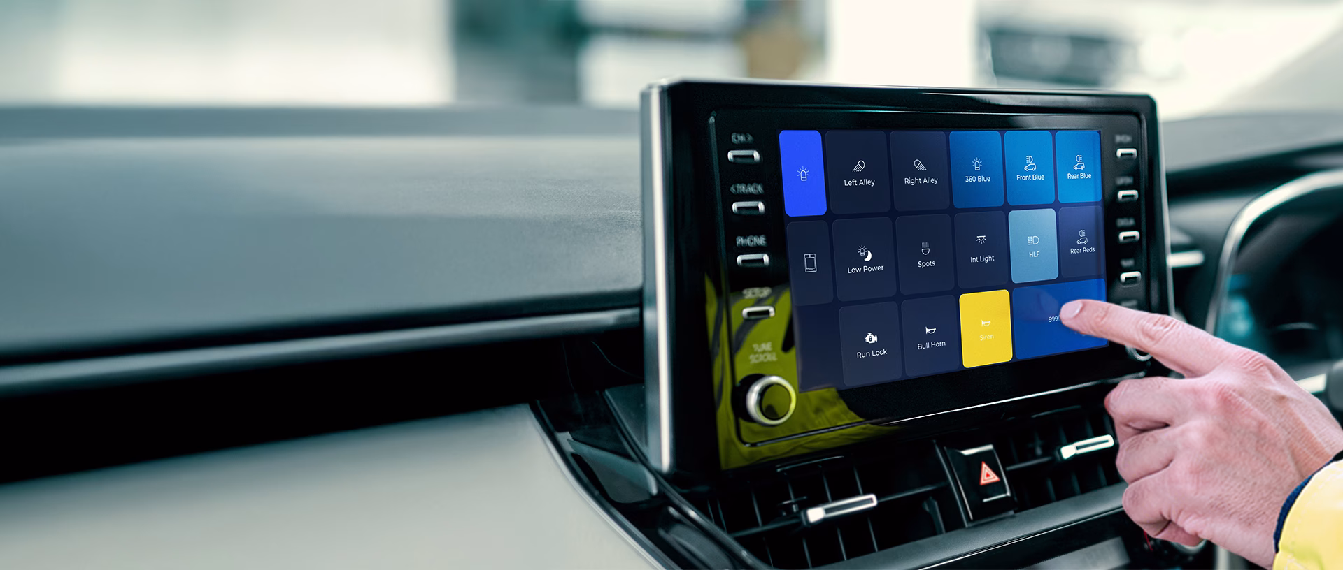 UniScreen OEM Touchscreen integration shown on Toyota Corolla infotainment screen with wide shot of dashboard and steering wheel. Hand pressing screen with hi-vis cuff.