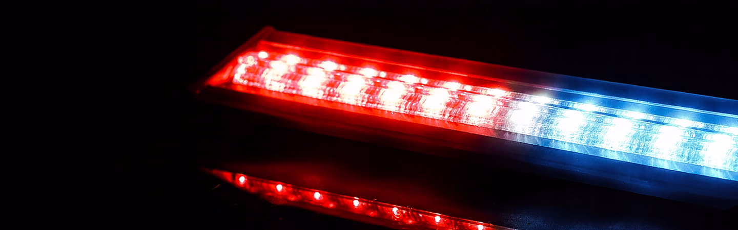 Blue and Red FlexiScreen LED module on a glossy black surface with reflecting lights
