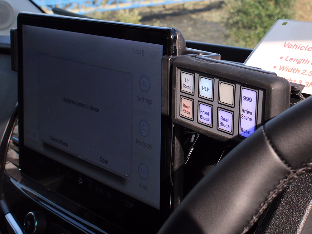 MCS-T8 Handset mounted on the dash of a HM Coastguard Ford Transit OSV shown cropped at an angle next to the vehicle's infotainment screen.
