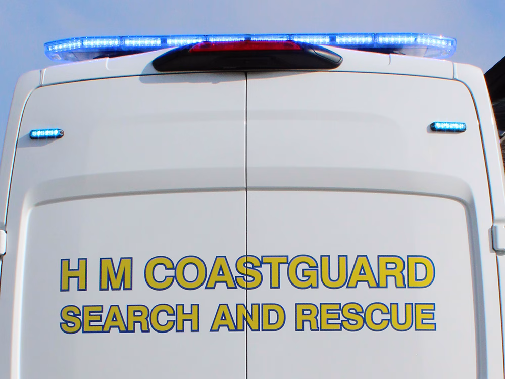 Closely cropped view of the upper back doors of a HM Coastguard Ford Transit OSV with Raiden Lightbar and 6-Way Mini Stealths lit in blue.