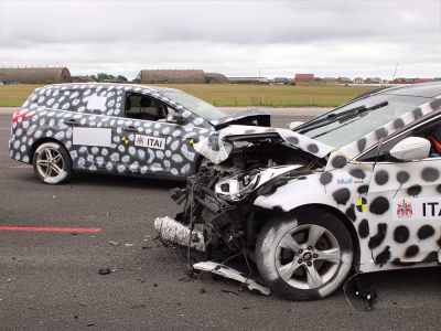 Staged crash of black and white vehicles with contrasting spray painted spots and heavily damaged front ends taken on an airfield runway at ITAI Crash Day 2026