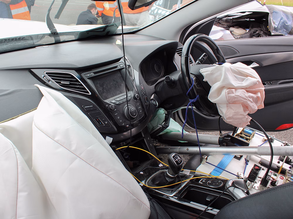 Crash vehicle interior with deactivated airbags and telematics units at ITAI Crash Day 2026